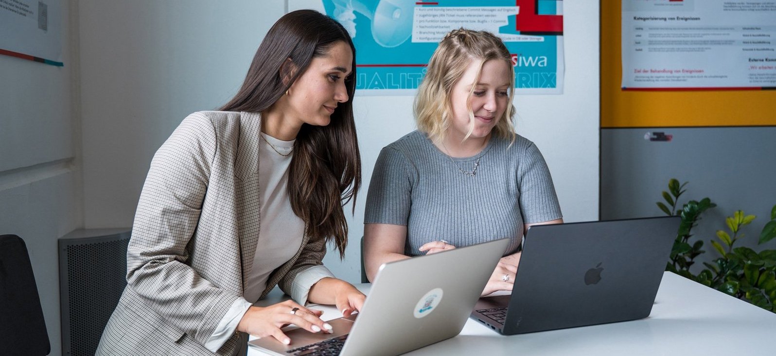SIWA Mitarbeiterinnen bei der Arbeit vorm Laptop an einem Besprechungstisch