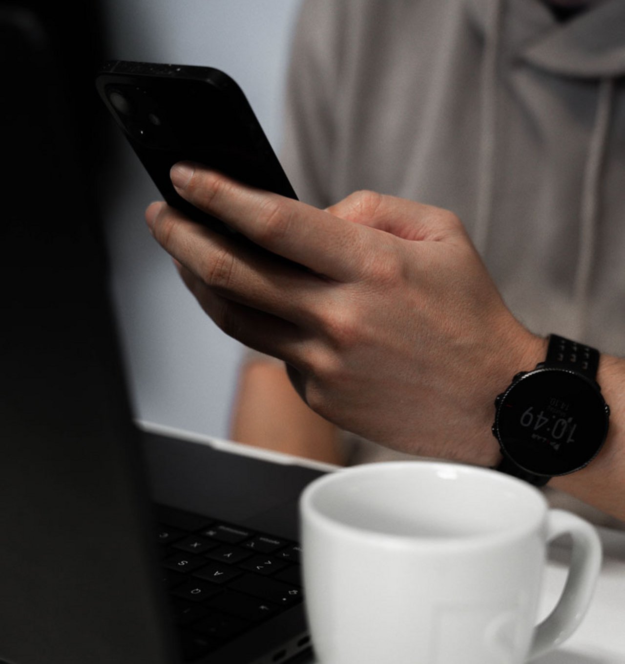 Ausschnitt einer Person mit Laptop und Smartphone