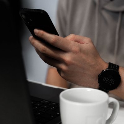 Ausschnitt einer Person mit Laptop und Smartphone