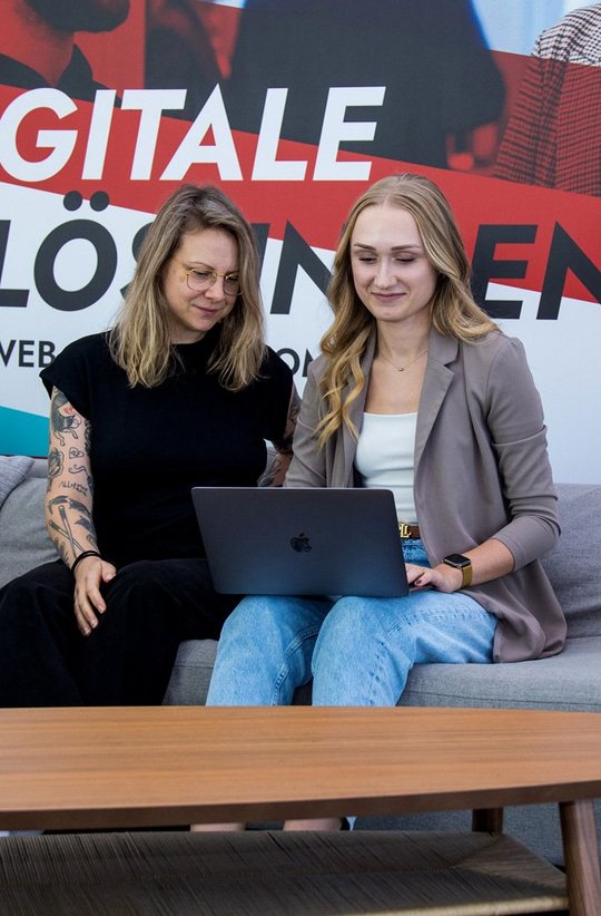 SIWA Webdesignerin und PSM sitzen mit dem Laptop auf der Couch